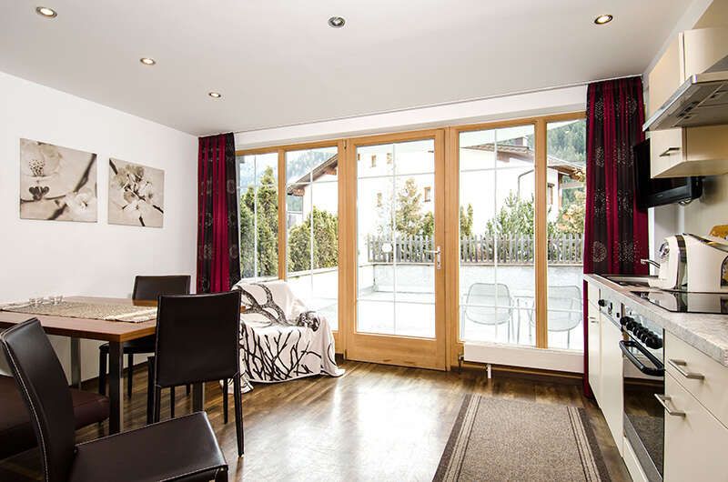 Kitchen and dining area with balcony in Ambiente Apartments