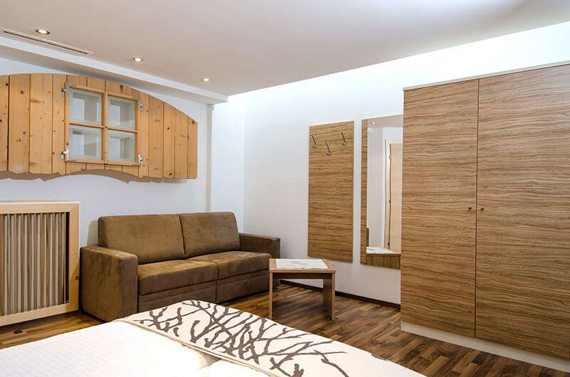 Bedroom with seating area and closet in the Ambiente Apartments